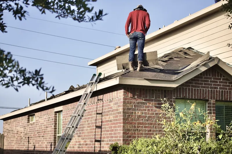Professional roofer working on a residential roof in Hill